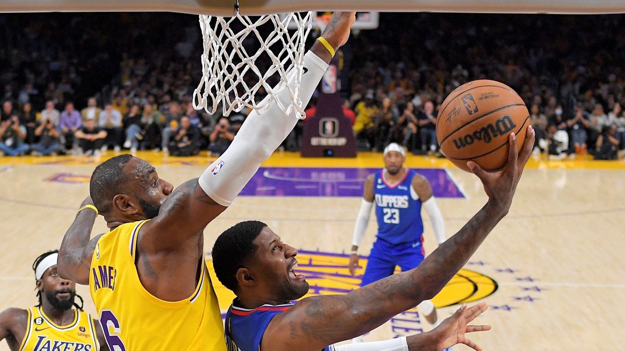 Los Angeles Clippers guard Paul George, right, shoots as Los Angeles Lakers forward LeBron James defends during the second half of an NBA basketball game Thursday in Los Angeles. (AP Photo/Mark J. Terrill)