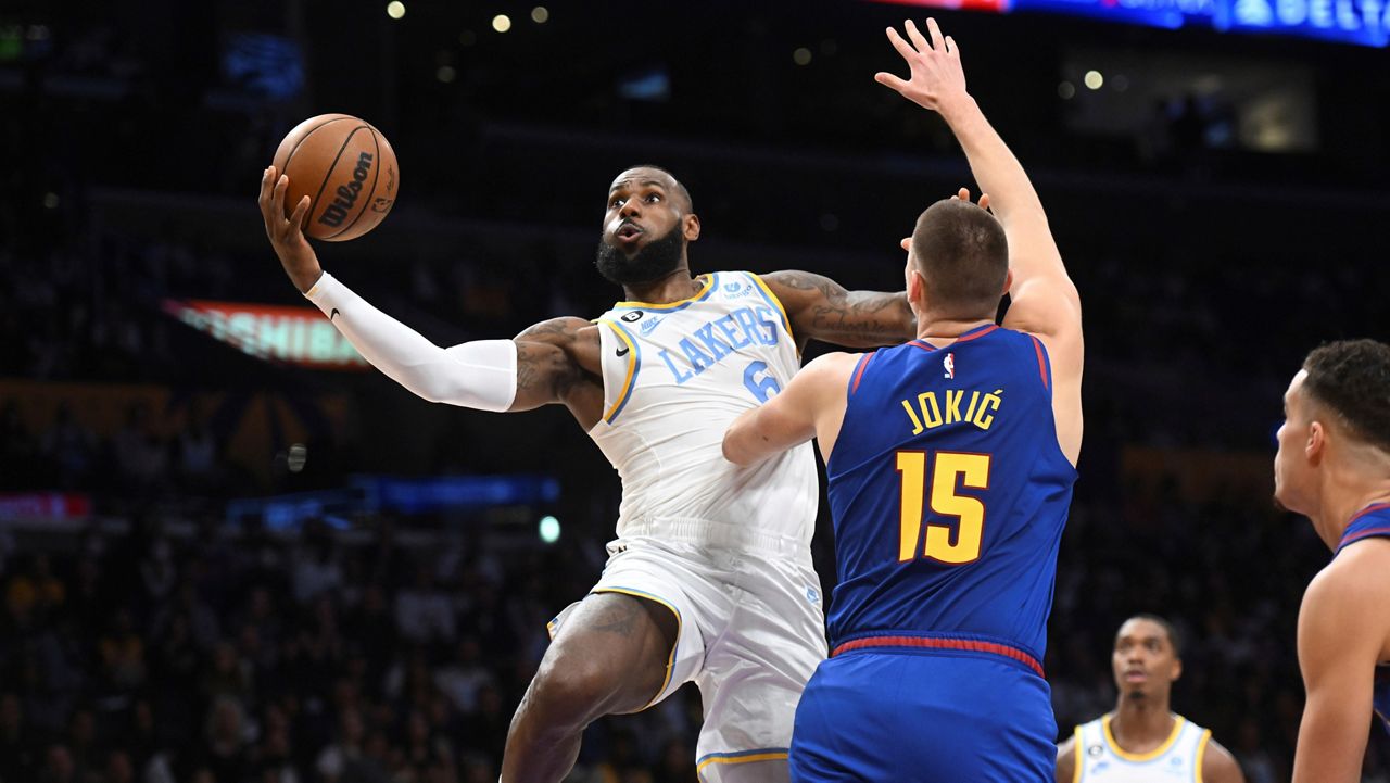 Los Angeles Lakers forward LeBron James (6) goes to the basket against Denver Nuggets center Nikola Jokic (15) during the first half of an NBA basketball game Sunday in Los Angeles. (AP Photo/Michael Owen Baker)