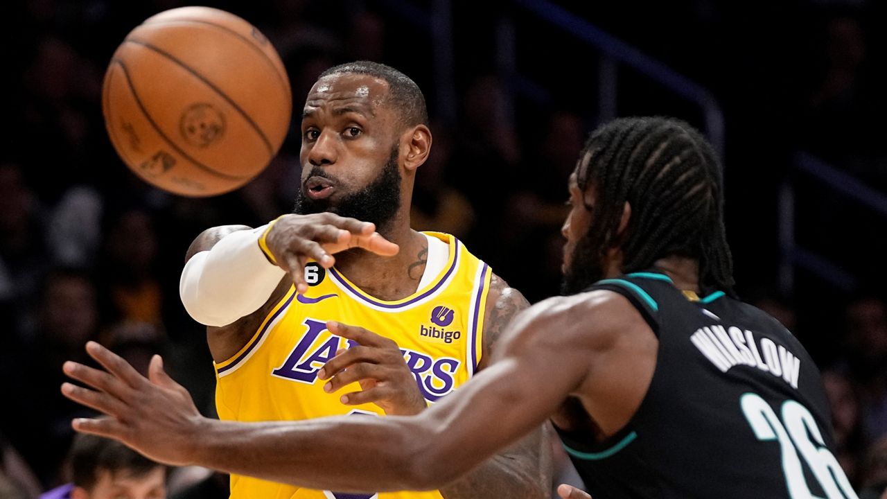 Los Angeles Lakers forward LeBron James, left, passes the ball as Portland Trail Blazers forward Justise Winslow defends during the first half of an NBA basketball game Wednesday in Los Angeles. (AP Photo/Mark J. Terrill)
