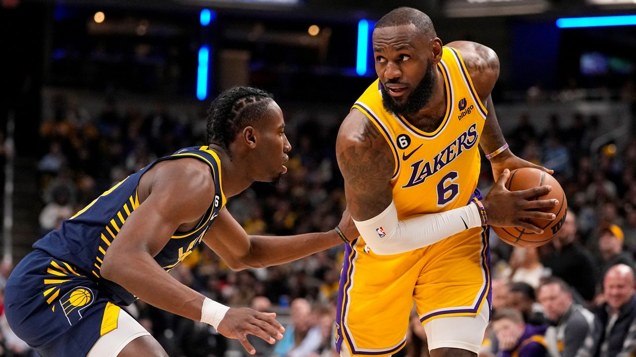 Los Angeles Lakers forward LeBron James (6) is defended by Indiana Pacers forward Aaron Nesmith (23) during the first half of an NBA basketball game Thursday in Indianapolis. (AP Photo/Michael Conroy)