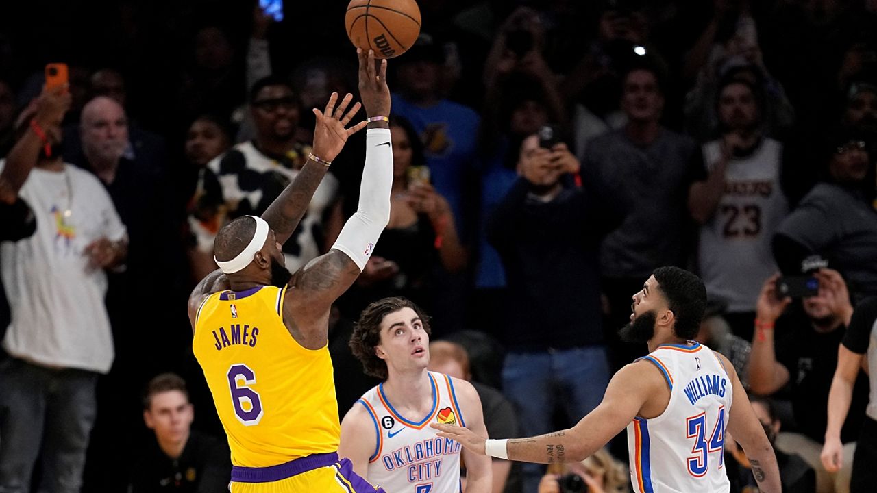 Los Angeles Lakers forward LeBron James, left, scores to pass Kareem Abdul-Jabbar to become the NBA’s all-time leading scorer as Oklahoma City Thunder guard Josh Giddey, center, and forward Kenrich Williams defend during the second half of an NBA basketball game Tuesday, in Los Angeles. (AP Photo/Mark J. Terrill)