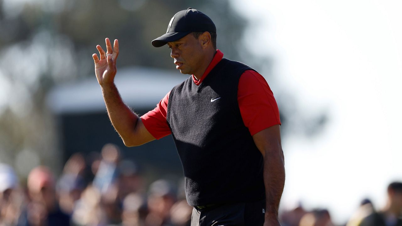 Tiger Woods waves to the gallery on the third green Sunday during the final round of the Genesis Invitational golf tournament at Riviera Country Club in the Pacific Palisades area of Los Angeles. (AP Photo/Ryan Kang)