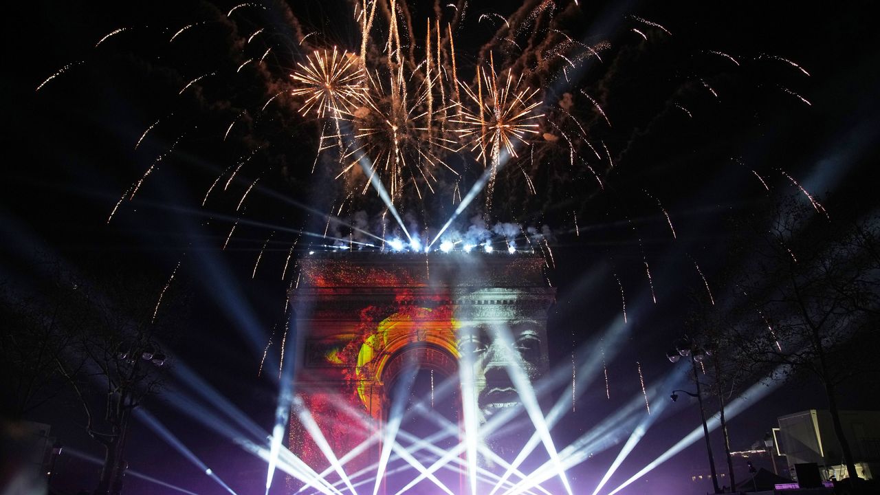 A light show is projected on the Arc de Triomphe as fireworks explode during New Year celebrations on the Champs Elysees in Paris, France, Wednesday, Dec. 31, 2025. (AP Photo/Christophe Ena)
