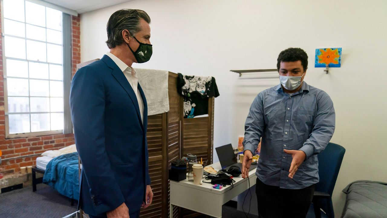 California Gov. Gavin Newsom, left, listens to Zachary Wright, a 25-year-old patient at Project 180, while visiting the facility in Los Angeles on March 10, 2022. Gov. Newsom's proposal to connect more homeless people to mental health services is making its way through the Legislature despite deep concerns by legislators that there isn't enough staffing or housing to make the program work while forcing people into treatment against their will. (AP Photo/Jae C. Hong, File)