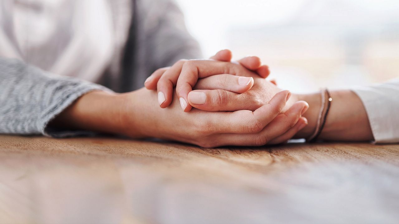 Person offering support, holding a hand