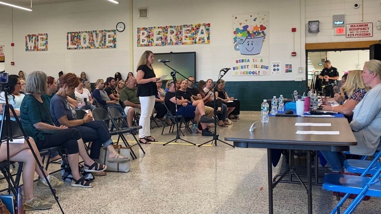 Woman addresses school board.