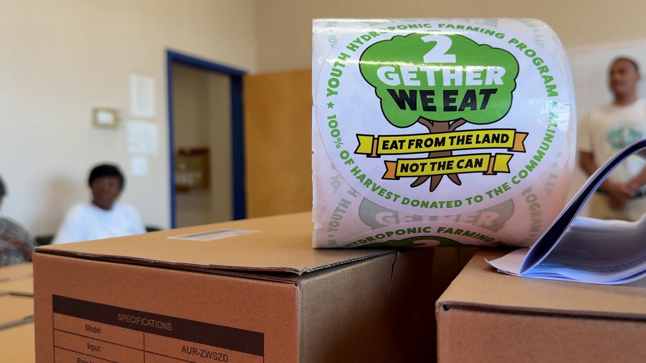 2Gether We Eat stickers on hydroponic garden boxes at the Worcester Senior Center. (Spectrum News 1/Dan Reidy)