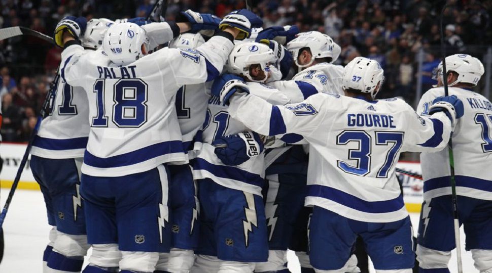 Tampa Bay Lightning right wing Nikita Kucherov is mobbed by teammates after scoring the winning goal in overtime of an NHL hockey game against the Colorado Avalanche Monday, Feb. 17, 2020, in Denver. The Lightning won 4-3. (AP Photo/David Zalubowski)