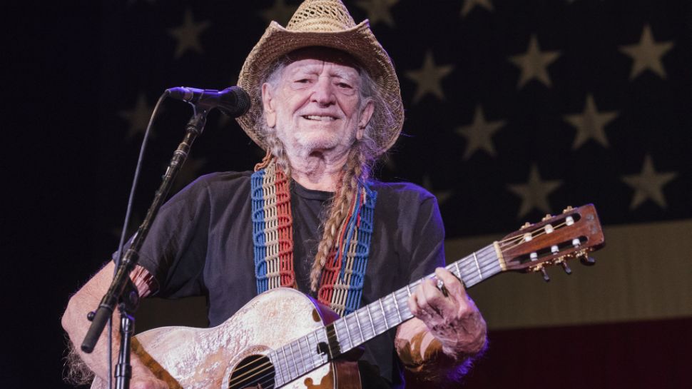 Willie Nelson plays the guitar at a past Fourth of July Picnic. (Photo Credit: Regina Pyne)