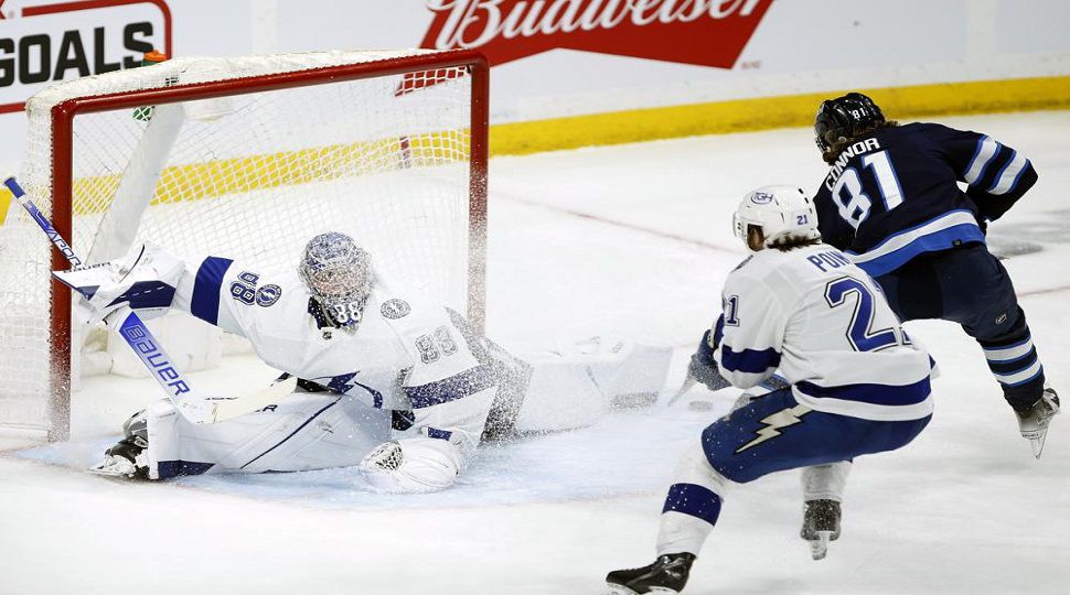 Winnipeg Jets' Kyle Connor (81) scores the game winner on Tampa Bay Lightning goaltender Andrei Vasilevskiy (88) as Brayden Point (21) defends during the third period of an NHL hockey game Tuesday, March 8, 2022 in Winnipeg, Manitoba.(Fred Greenslade/The Canadian Press via AP)