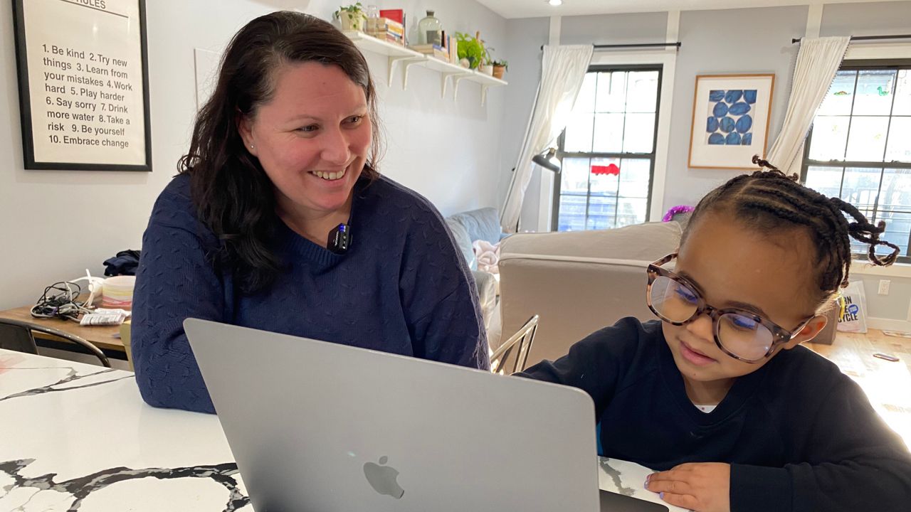 Whitney McMullan and her daughter, Frankie, who is home from 3-K after a classmate tested positive for coronavirus. Frankie swiped her mom's blue light glasses and commandeered her work laptop.