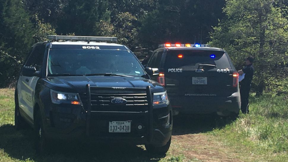 Austin Police Department vehicles in a wooded area where a body was discovered on March 21, 2019. (Spectrum News photograph)