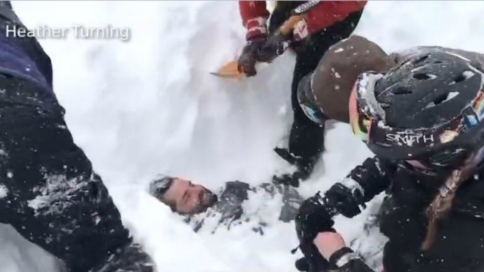 Rescuers work to help five people trapped by an avalanche