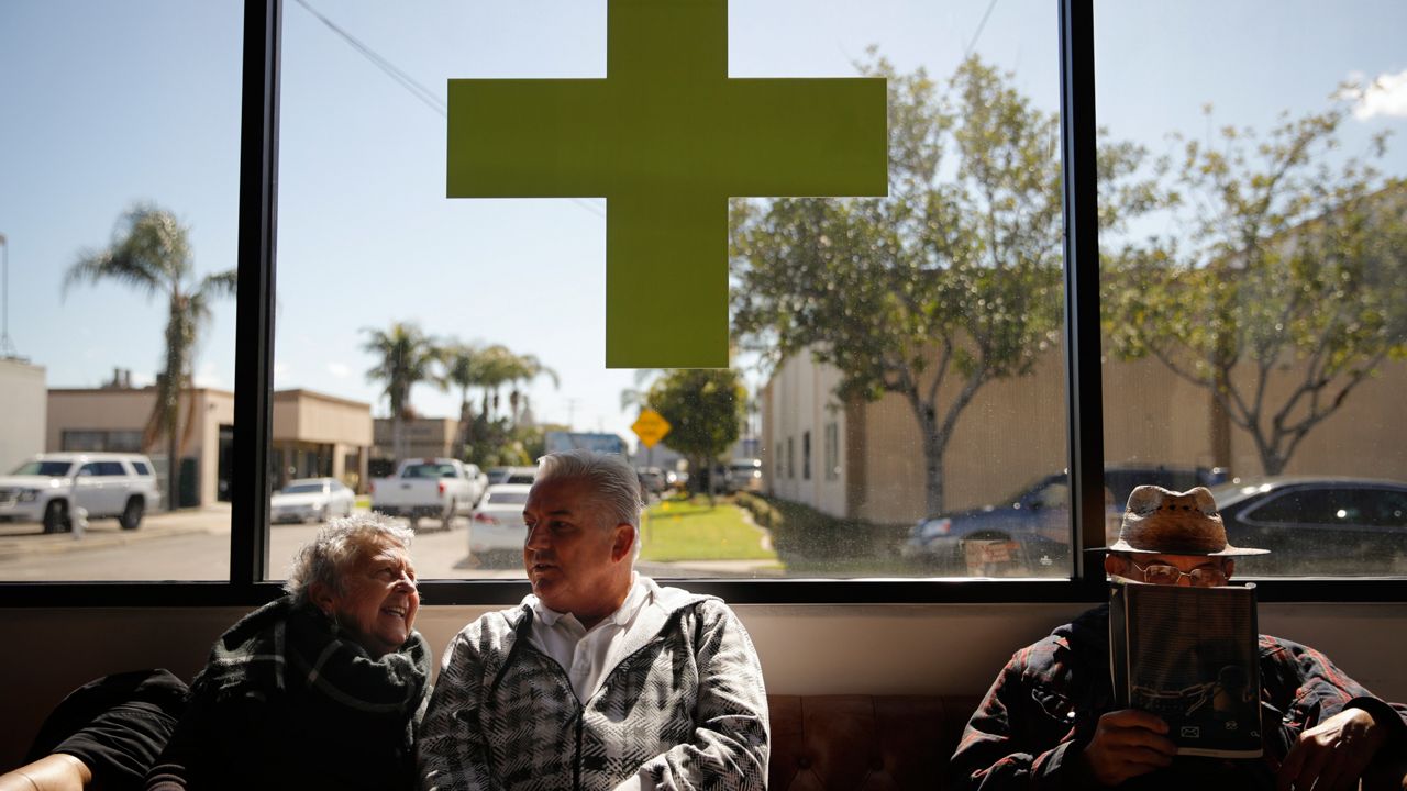 Kay Nelson, left, and Bryan Grode, retried seniors from Laguna Woods Village, chat in the lobby of Bud and Bloom cannabis dispensary while waiting for a free shuttle to arrive in Santa Ana, Calif., Feb. 19, 2019.