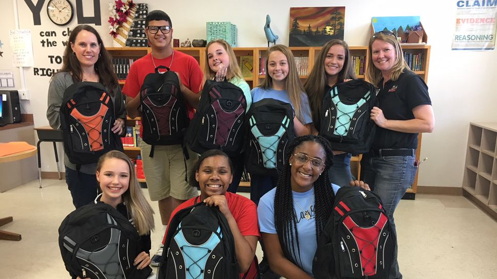 Eighth graders at Jewett School of the Arts, along with their teacher, Sonya Barnes, show off backpacks full of hygiene products and school supplies which they packed and will send via World Vision to Syrian refugee children. (Stephanie Claytor, staff)