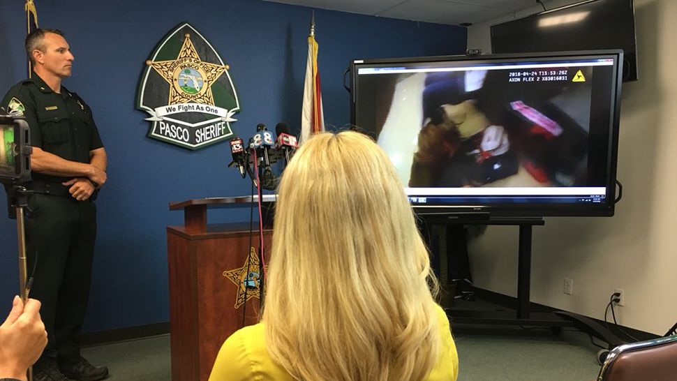 Pasco Sheriff Chris Nocco (left) looks on as assembled media watch body cam video showing a deputy's recent encounter with a Sunlake High School student, April 25, 2018. (Sarah Blazonis, staff)