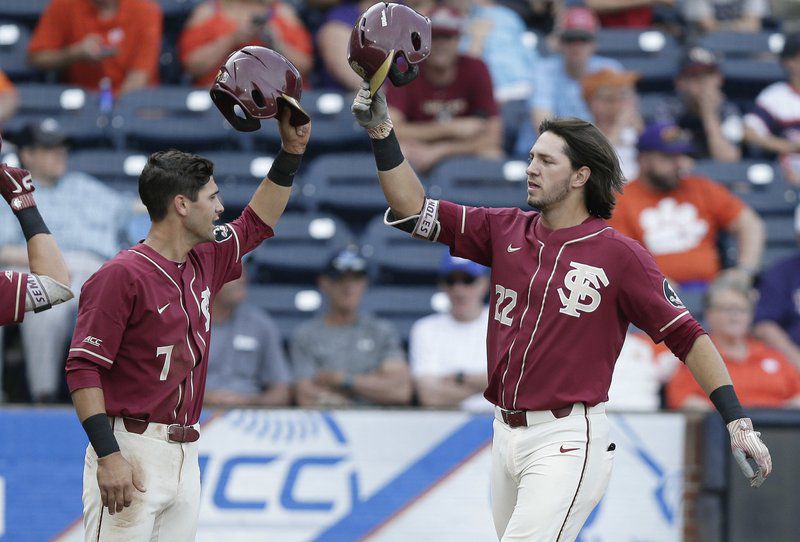 Florida State's Drew Mendoza (22) gets congratulated by Steven Wells (7) after a 2nd-inning 2-run blast vs. Clemson (AP Photo/Gerry Broome)
