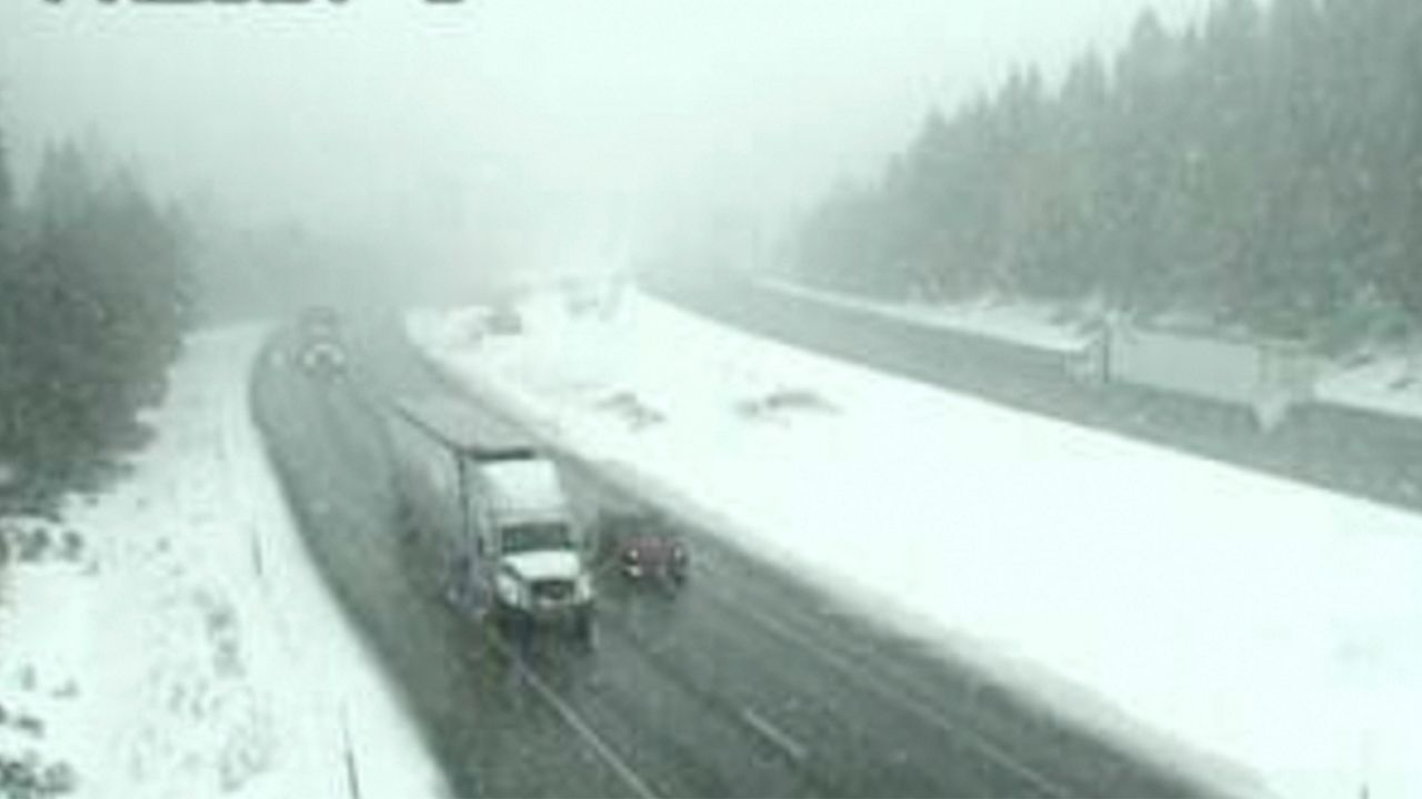 In this image taken from video from a Caltrans remote video traffic camera, traffic makes it way through snow showers along Interstate 5 at Summit Drive near Mt. Shasta, Calif., on Tuesday, March 9, 2021. A cold, late-winter Pacific storm is bringing rain and snow to California. (Caltrans via AP)