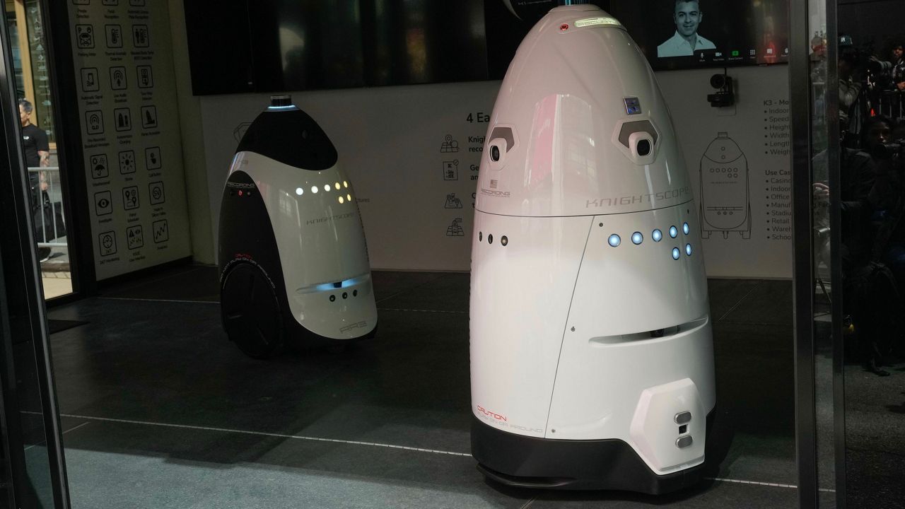 Mayor Eric Adams showed off the K5, pictured here, during a news conference last month. The white, cone-shaped robot is shown next to a smaller, similar-looking model. (Michael Appleton/Mayoral Photography Office)
