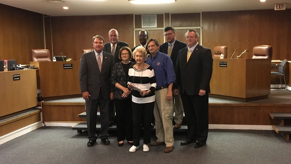 Winter Haven city commissioners stand with Margaret Stewart, widow of Col. Peter Stewart, and Jim Stewart, the colonel's son. The city passed a resolution honoring Stewart's service on Tuesday. (Laurie Davison, staff)