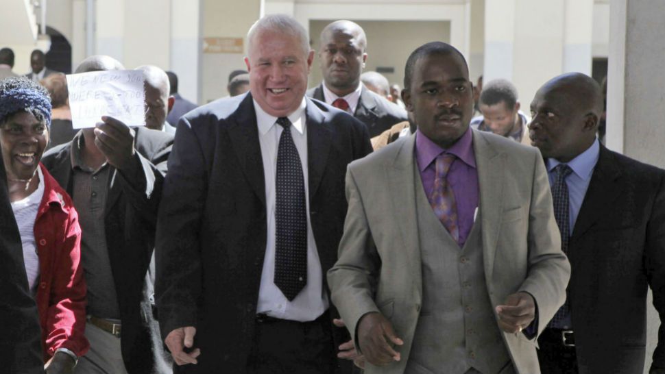 In this May, 10, 2010 photo Roy Bennett, center left, leaves the High Court Harare, Zimbabwe, after he was acquitted of terrorism charges. New Mexico State Police said Thursday, Jan. 18, 2018 that Zimbabwean opposition leader Roy Bennett died in helicopter crash. (AP Photo/Tsvangirai Mukwazhi)