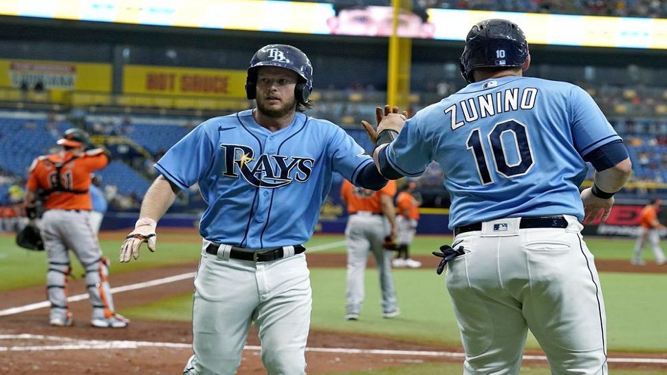 Tampa Bay Rays' Brett Phillips and Mike Zunino (10) celebrate after scoring on a two-run double by Brandon Lowe off Baltimore Orioles pitcher Jorge Lopez during the fourth inning of the Rays' 5-4 win. (AP Photo/Chris O'Meara)