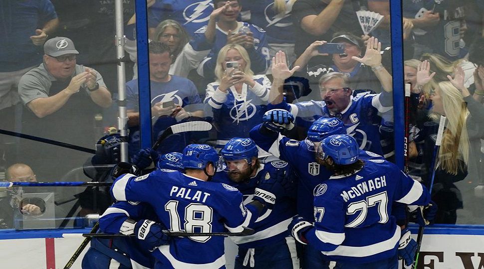 Teammates surround and congratulated Tampa Bay Lightning center Steven Stamkos (91) after his goal during the first period of Game 6 of the NHL hockey Stanley Cup Finals against the Colorado Avalanche on Sunday, June 26, 2022, in Tampa, Fla. (AP Photo/John Bazemore)
