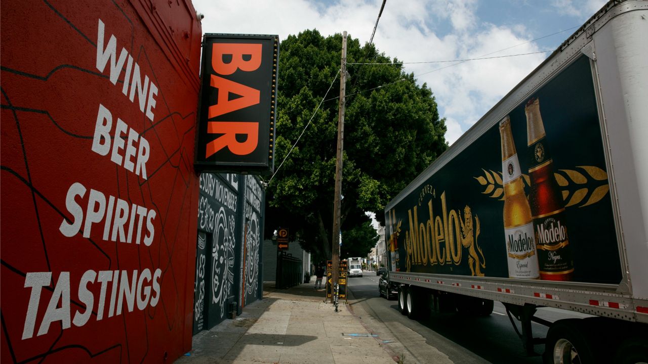 A truck with a beer advertisement stops in front of a bar in Los Angeles, Monday, June 29, 2020. (AP Photo/Jae C. Hong)