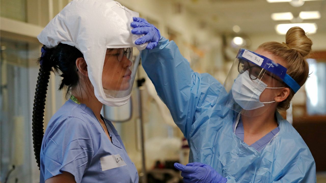 Medical personnel stand together in PPE (AP Image/File)