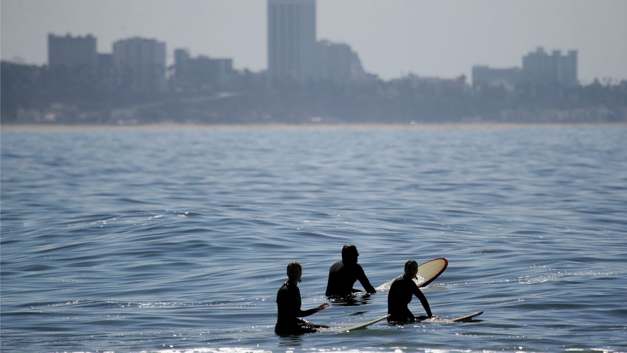 Surfers wait for waves on Topanga Beach Wednesday, May 13, 2020, in Los Angeles. (AP Photo/Marcio Jose Sanchez)