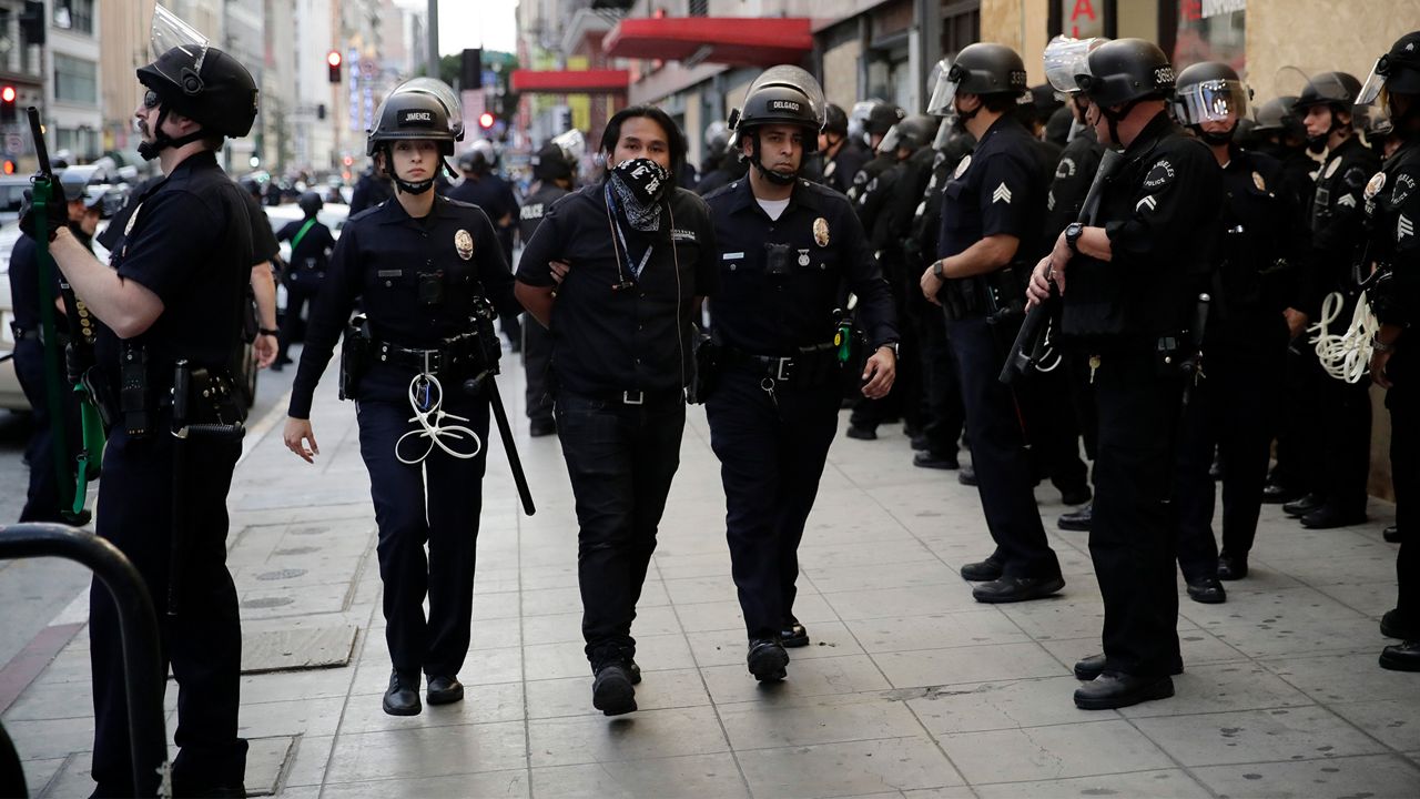 A demonstrator is taken into custody after the city's curfew went into effect Tuesday, June 2, 2020, in Los Angeles, as protests continue nationwide over the death of George Floyd on May 25 while in police custody in Minneapolis. (AP Photo/Jae C. Hong)