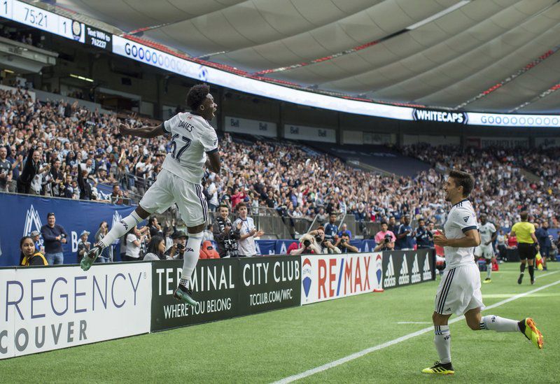 Alphonso Davies, left, and Nicolas Mezquida celebrate Davies’ goal against Orlando City during the second half of City's 5-2 loss to the Whitecaps. (Darryl Dyck/The Canadian Press via AP)
