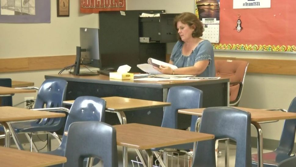 A teacher sits at her desk. (Spectrum News footage)