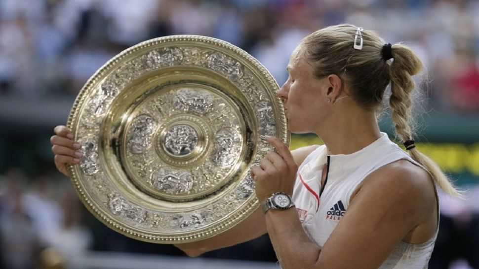 Germany's Angelique Kerber kisses the trophy after winning the women's singles final at Wimbledon, defeating Serena Williams 6-3, 6-3. (AP Photo/Tim Ireland)