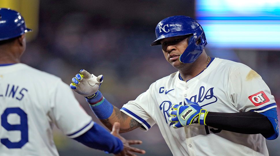 Kansas City Royals' Salvador Perez, celebrates with first base coach Damon Hollins after hitting an RBI single during the seventh inning of a baseball game against the Tampa Bay Rays Wednesday, July 3, 2024, in Kansas City, Mo. (AP Photo/Charlie Riedel)