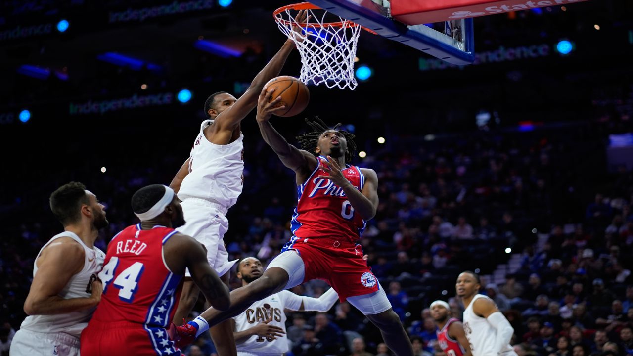 Philadelphia 76ers' Tyrese Maxey (0) goes up for a shot against Cleveland Cavaliers' Evan Mobley (4) during the second half of an NBA basketball game, Friday, Feb. 23, 2024, in Philadelphia.