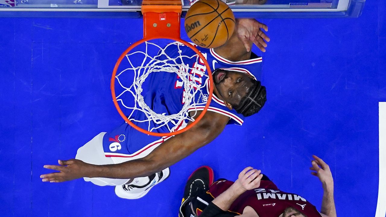 Philadelphia 76ers' Joel Embiid, left, shoots over Miami Heat's Kevin Love during the first half of an NBA basketball play-in tournament game Wednesday, April 17, 2024, in Philadelphia. (AP Photo/Chris Szagola)