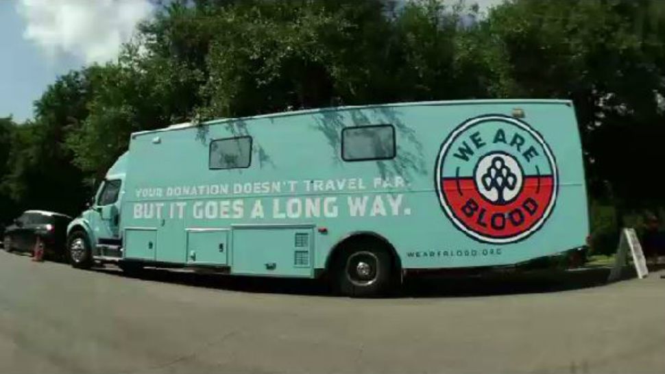 A We Are Blood donation truck is parked beneath trees. (Spectrum News footage)