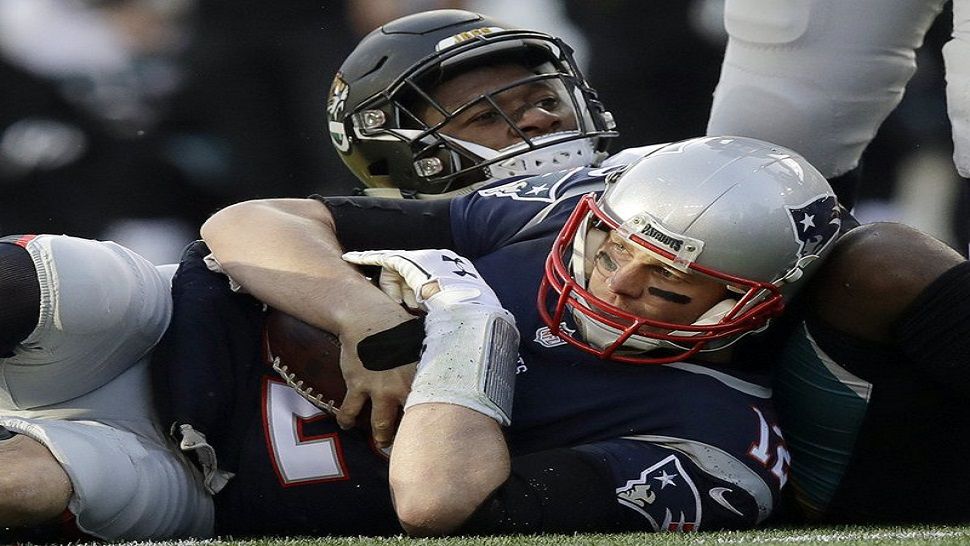 In this 2018 file photo, New England Patriots quarterback Tom Brady, front, holds onto the ball as he goes down against Jacksonville Jaguars defensive end Dante Fowler during the first half of the AFC championship. The Jaguars have suspended All-Pro cornerback Jalen Ramsey and Fowler for violating team rules and conduct unbecoming a Jaguars football player.  (AP Photo/Charles Krupa)
