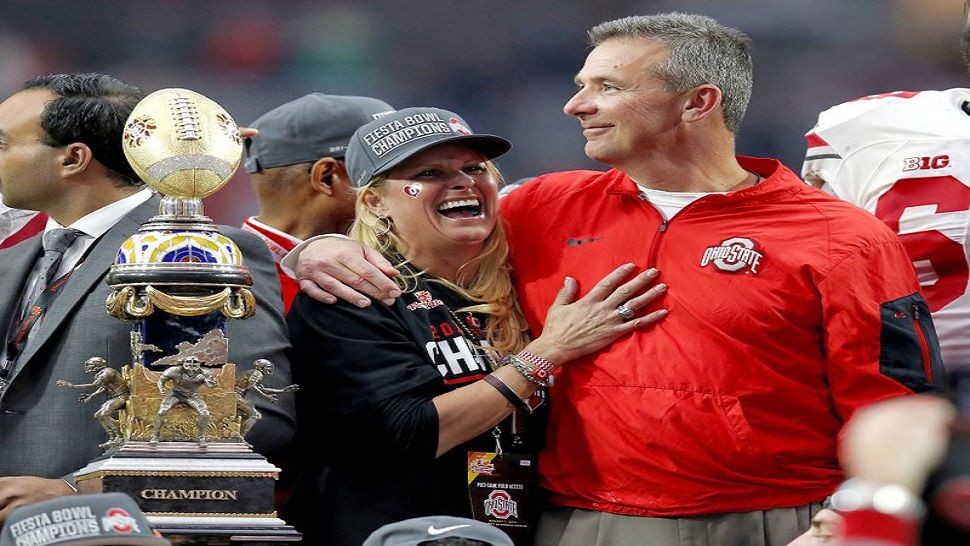 In this file photo, Ohio State head coach Urban Meyer hugs his wife, Shelley, after their 44-28 win over Notre Dame in the Fiesta Bowl NCAA college football game, in Glendale, Ariz. Ohio State placed Meyer on paid administrative leave Wednesday, Aug. 1, 2018, while it investigates claims that his wife knew about allegations of abuse against former Buckeyes assistant Zach Smith, who was fired last week. (AP Photo/Rick Scuteri)