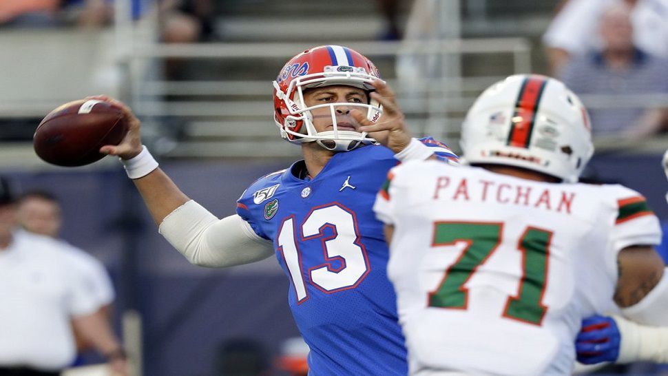 Florida quarterback Feleipe Franks (13) looks downfield as he's pressured by Bay Area native and Miami Hurricanes defensive lineman Scott Patchan (71).  The No. 8 Gators held on for a 24-20 win over Miami in Orlando.  (AP Photo/John Raoux)