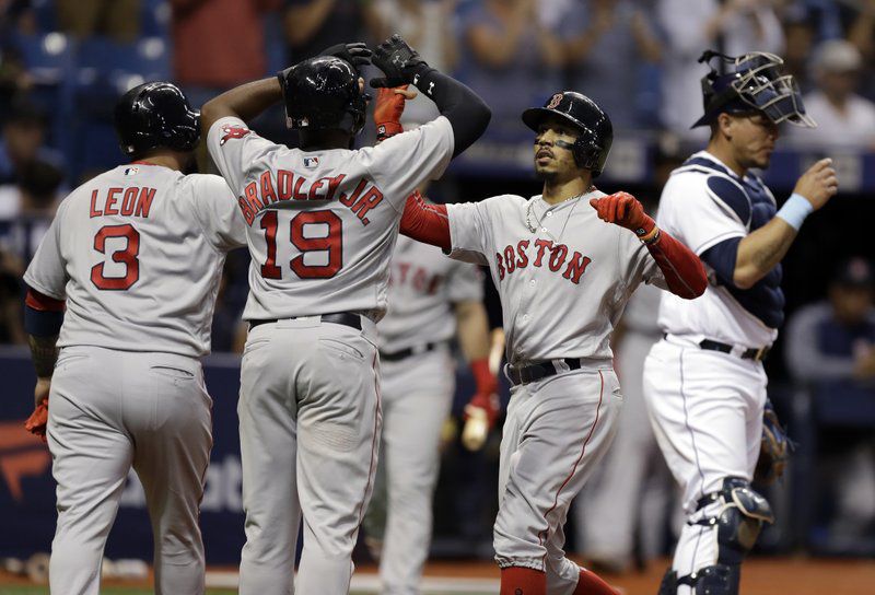 Boston Red Sox’s Mookie Betts, second from right, celebrates with Jackie Bradley Jr. and Sandy Leon after hitting a three-run home run off Tampa Bay Rays starting pitcher Jacob Faria during the third inning of a baseball game Tuesday, May 22, 2018, in St. Petersburg, Fla. Catching for the Rays is Wilson Ramos. (AP Photo/Chris O’Meara)