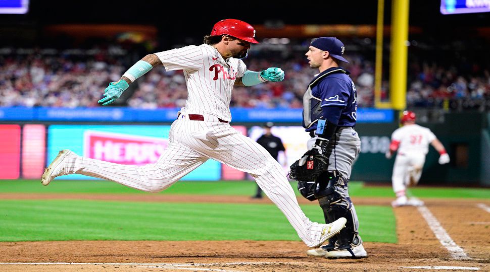 Philadelphia Phillies' Nick Castellanos, left, scores a run past Tampa Bay Rays' Ben Rortvedt during the sixth inning of a baseball game, Wednesday, Sept. 11, 2024, in Philadelphia. (AP Photo/Derik Hamilton)