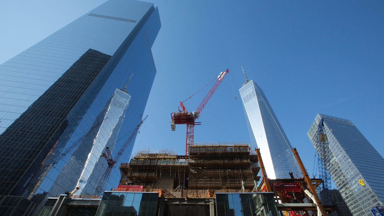 A construction crane works on top of the rising steel frame of Three World Trade Center, center, November 20, 2014. (AP Photo/Mark Lennihan)
