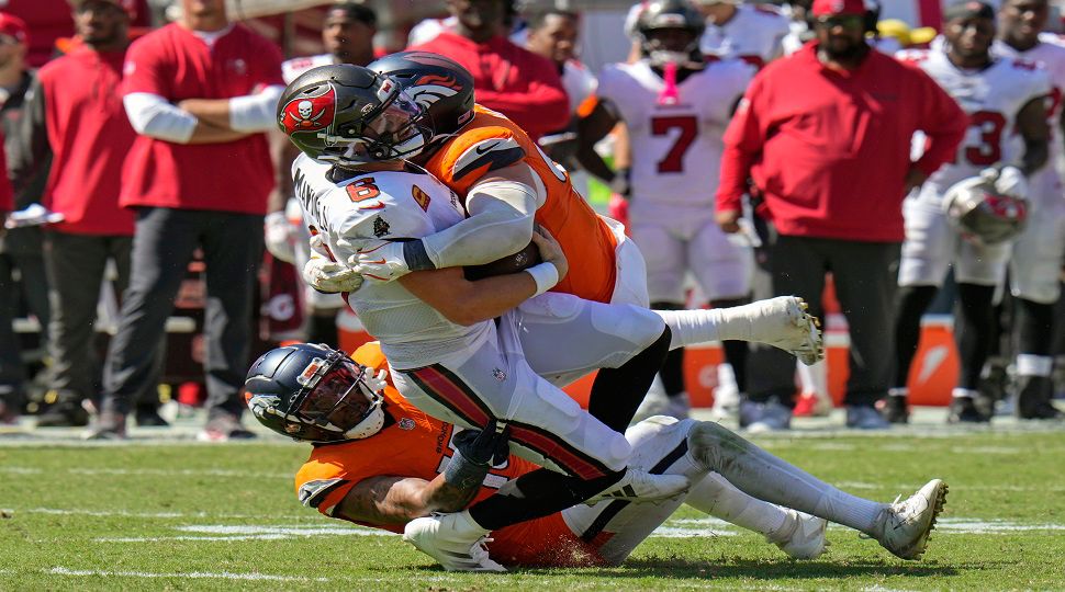 Tampa Bay Buccaneers quarterback Baker Mayfield, center, is tackled by Denver Broncos defensive end Zach Allen on a fourth down play during the second half of an NFL football game, in Tampa, Fla. on Sunday, Sept. 22, 2024. (AP Photo/Chris O'Meara)