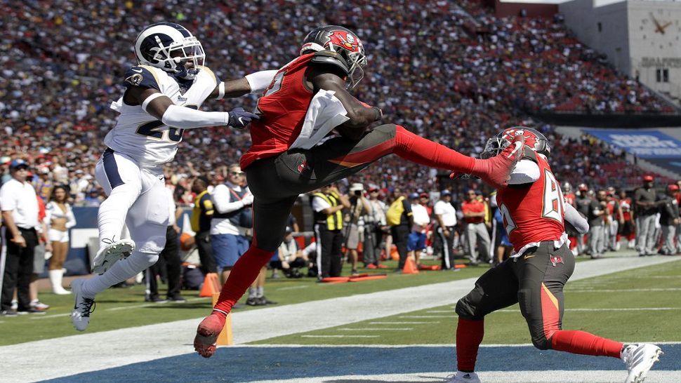 Tampa Bay Buccaneers wide receiver Chris Godwin, middle, catches a TD pass in front of Rams defensive back Nickell Robey-Coleman.  It was one of two scores for Godwin in the 55-40 Buccaneers win.  (AP Photo/Marcio Jose Sanchez)