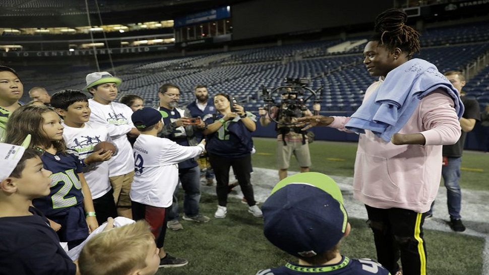 Seattle Seahawks linebacker Shaquem Griffin, right, who has only one hand, talks to kids from NubAbility Athletics, a non-profit organization that encourages youth with limb differences to be involved in mainstream sports. Griffin’s story will likely add another unplanned chapter on Sunday in Denver, one nobody could have expected on the day he was drafted by Seattle. He’ll do more than just play in his first NFL regular-season game. Griffin will be one of the starting linebackers for the Seahawks with K.J. Wright out due to minor knee surgery. (AP Photo/Stephen Brashear, File)
