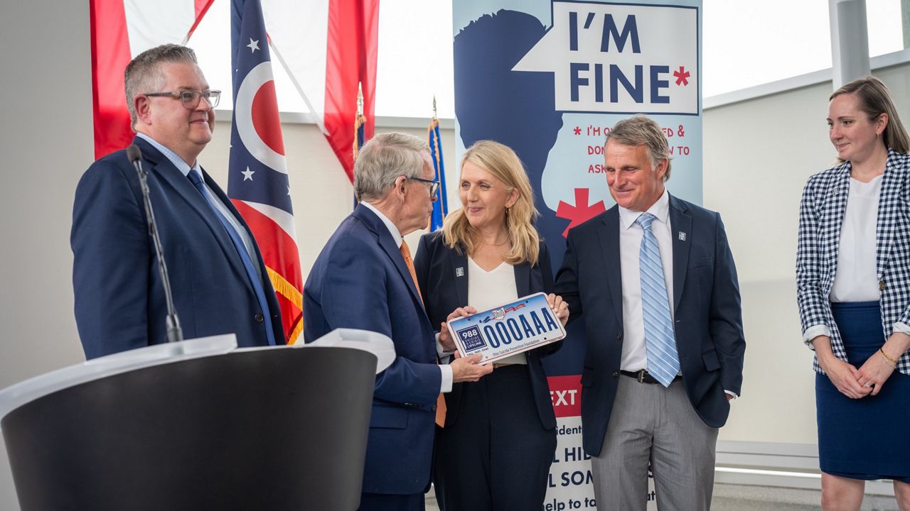 Gov. Mike DeWine, R-Ohio, presents a commemorative license plate to Debbie and Chip McClintock on Tuesday, May 20, 2025. (Gov. Mike DeWine's Office)