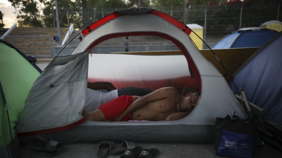 A Cuban migrant sleeps inside a tent at the foot of the Puerta Mexico bridge that crosses the border to Brownsville, Texas, from Matamoros, Mexico. Many immigrants at the border are either in line for an initial attempt to seek asylum in the U.S. or waiting for a court hearing in the U.S. after being sent back to Mexico. (AP Photo/Emilio Espejel)