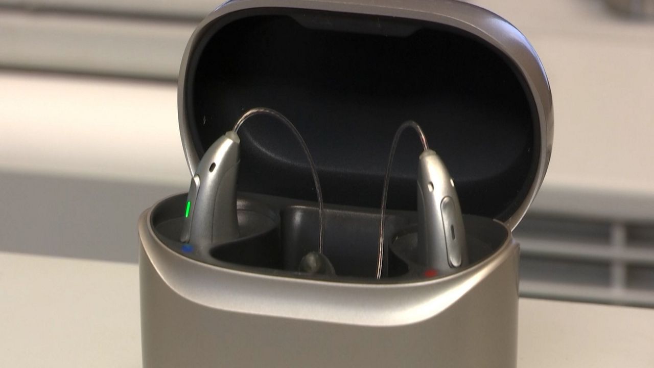  AI-powered hearing aids in their charging case, ready to enhance sound and reduce background noise with smart technology.